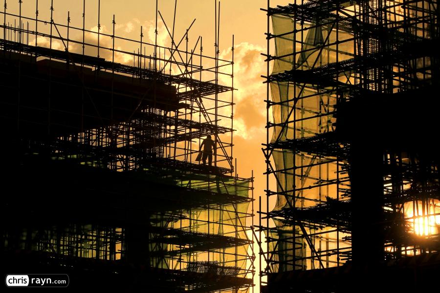 A Worker leaving the steel frame construction at sunset