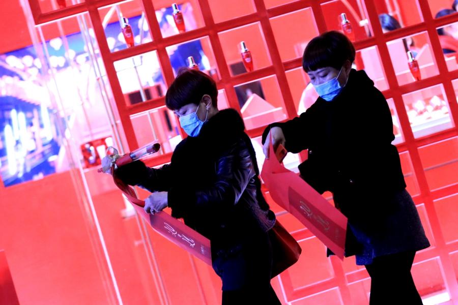 Two Masked Women Unpack Red Envelopes at Spring Festival