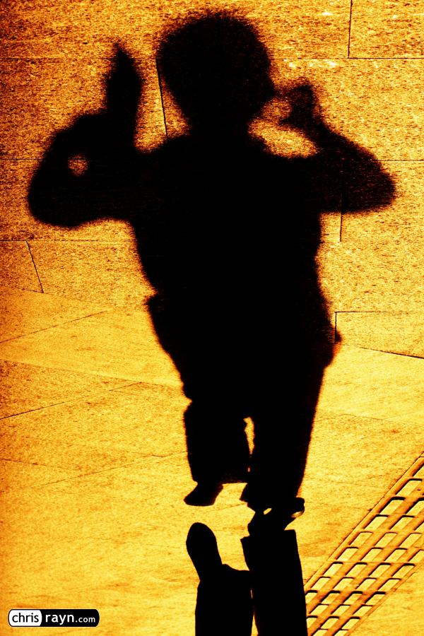 A preoccupied shadow is juggling a phone and tablet