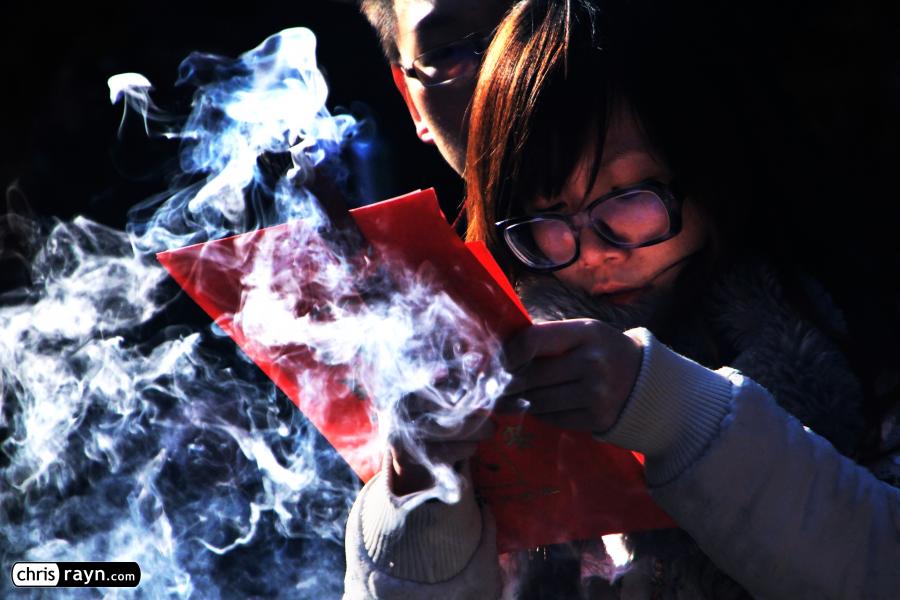 A couple sharing a moment of prayer, engulfed in incense