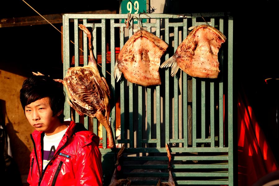 Local Shanghai Boy in Old Town with Dried Fish in Winter