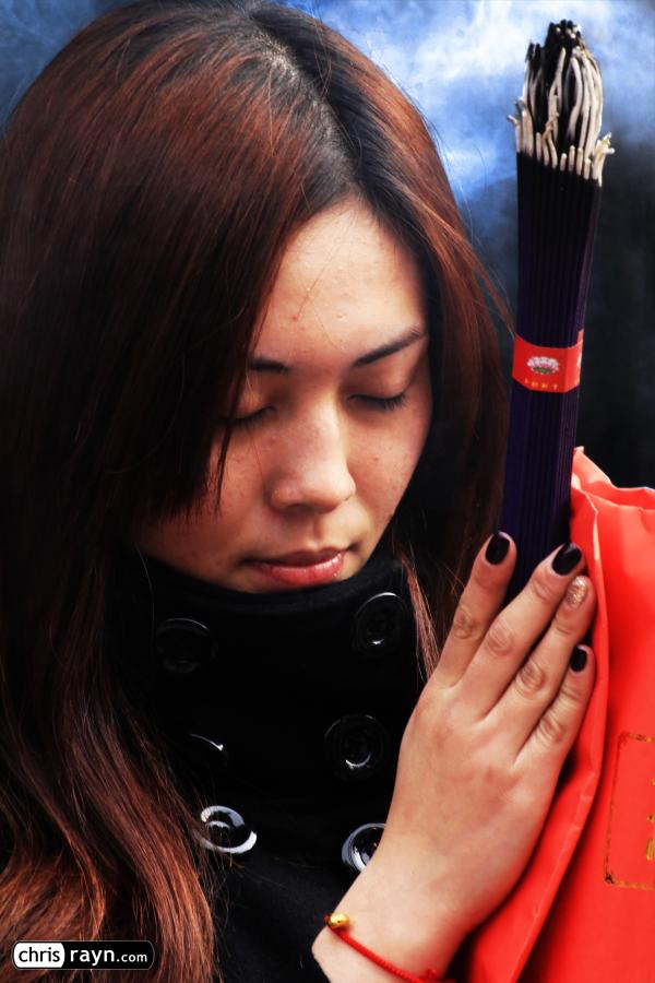 Well-protected from the cold, a young woman in deep prayer