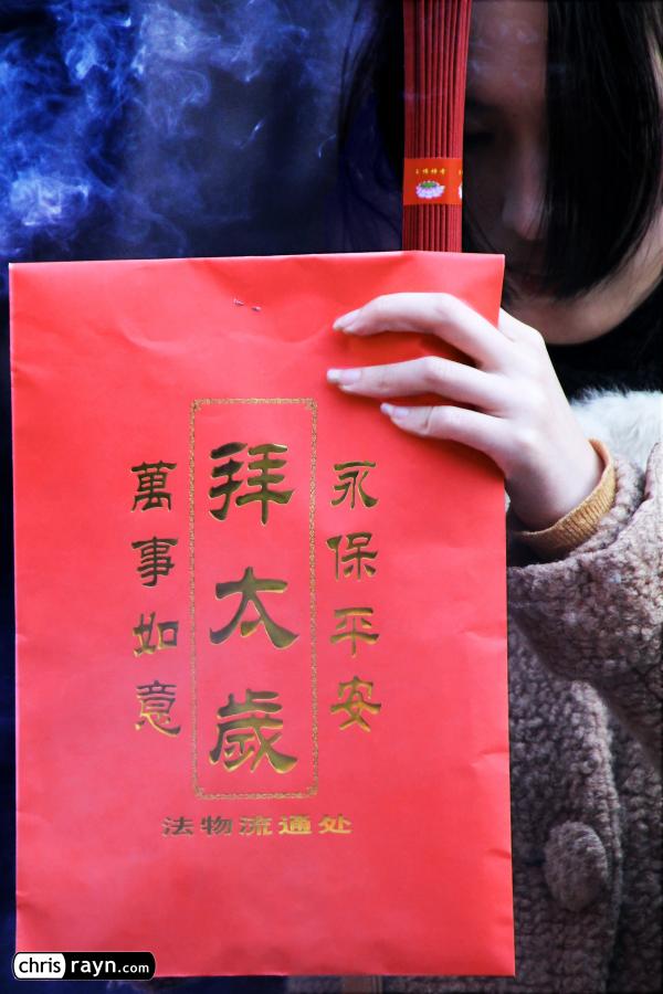 Holding a red envelope, for good fortune in the new year