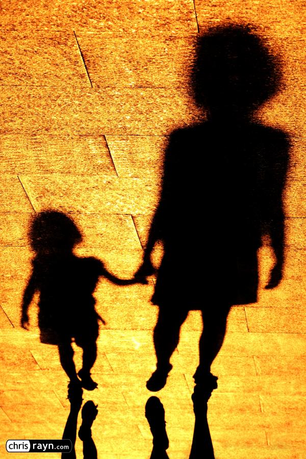 In shadows, a girl is looking up to her mother