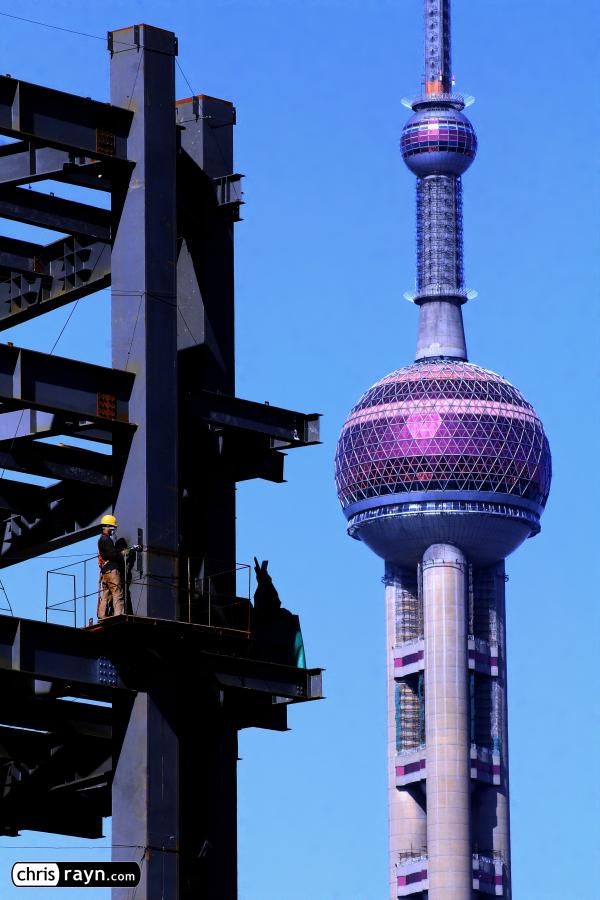 Welding a new high rise in front of Oriental Pearl Tower