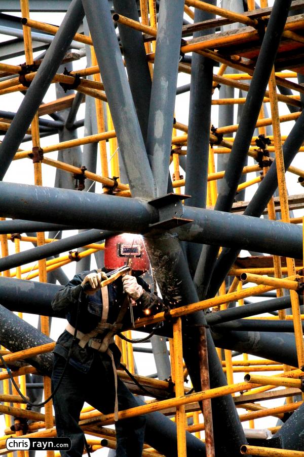Construction welder hidden in steel framework