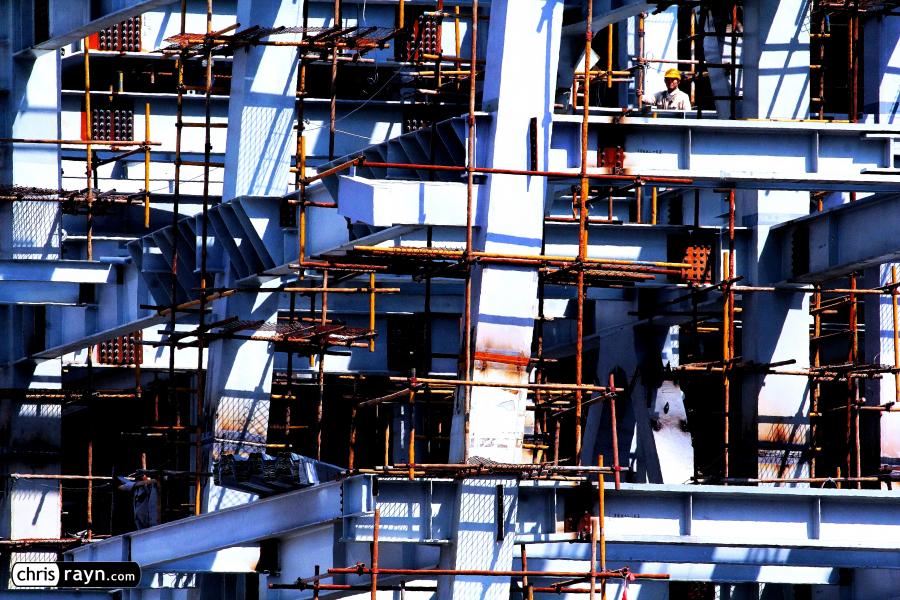 Construction worker hidden in a steel frame skeleton 